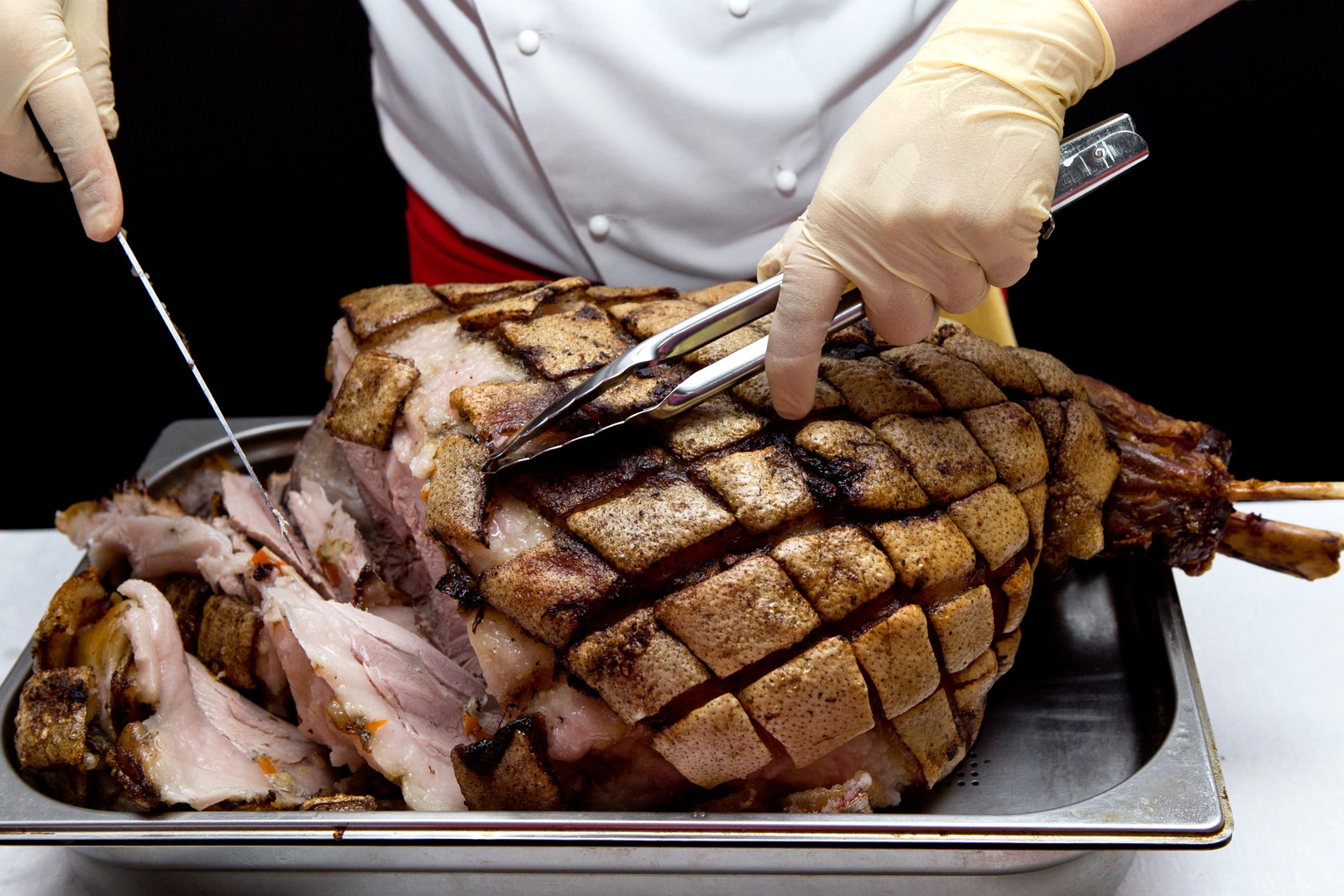 Pork. Chef cuts baked meat.